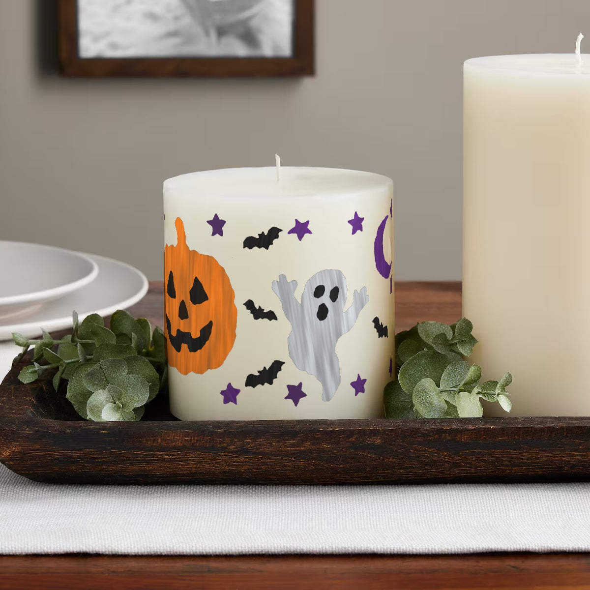 Spooky Night paint by numbers candle on a table: hand-painted jack-o'-lantern, ghost, bats, moon and stars all round an ivory pillar candle
